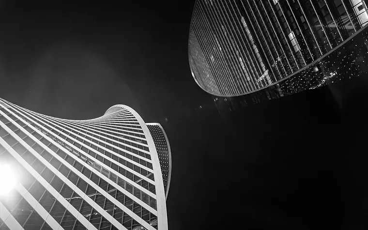 Glass office towers at night seen from below