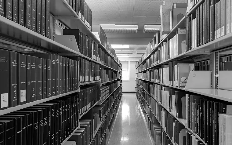 Aisle between library shelves of bound volumes