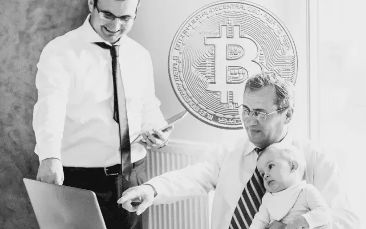 Two advisers and a child at a laptop before a large Bitcoin emblem