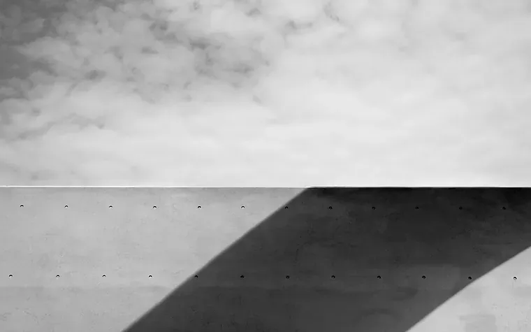 Concrete wall edge cutting a shadow against the sky