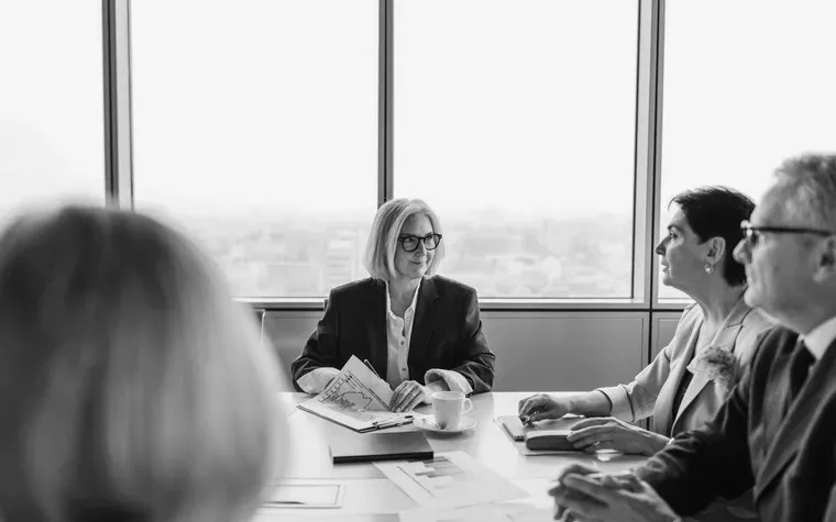 Advisers reviewing papers across a boardroom table