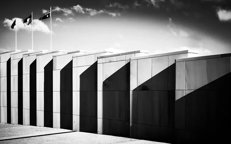 Government building facade with flagpoles