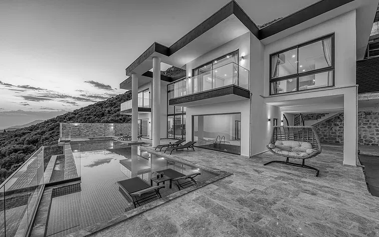 Modern hillside villa and pool at dusk