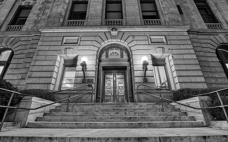 Lit stone entrance and steps of an institutional building