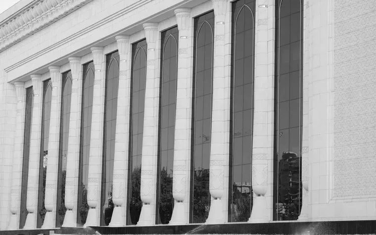 Colonnade of arched windows along a marble facade