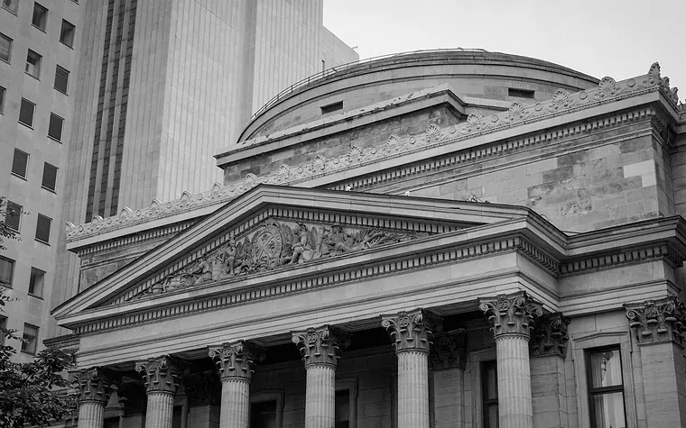 Neoclassical bank facade of columns and pediment below a dome